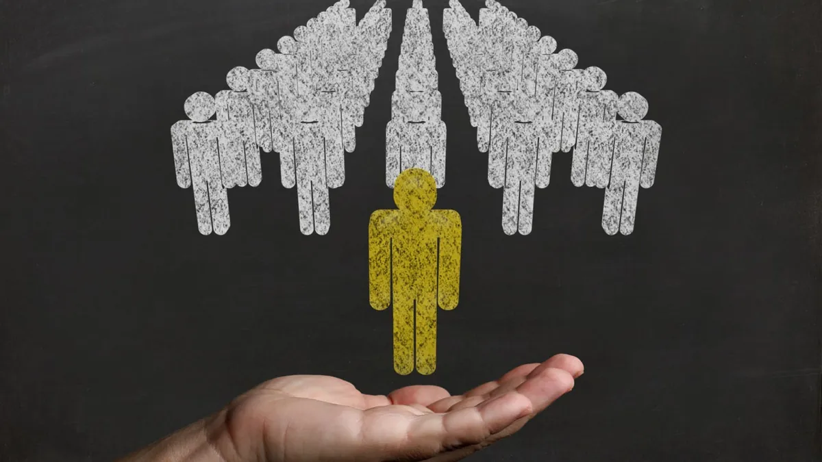 A hand holding a yellow person over a group of people
AI-generated content may be incorrect.